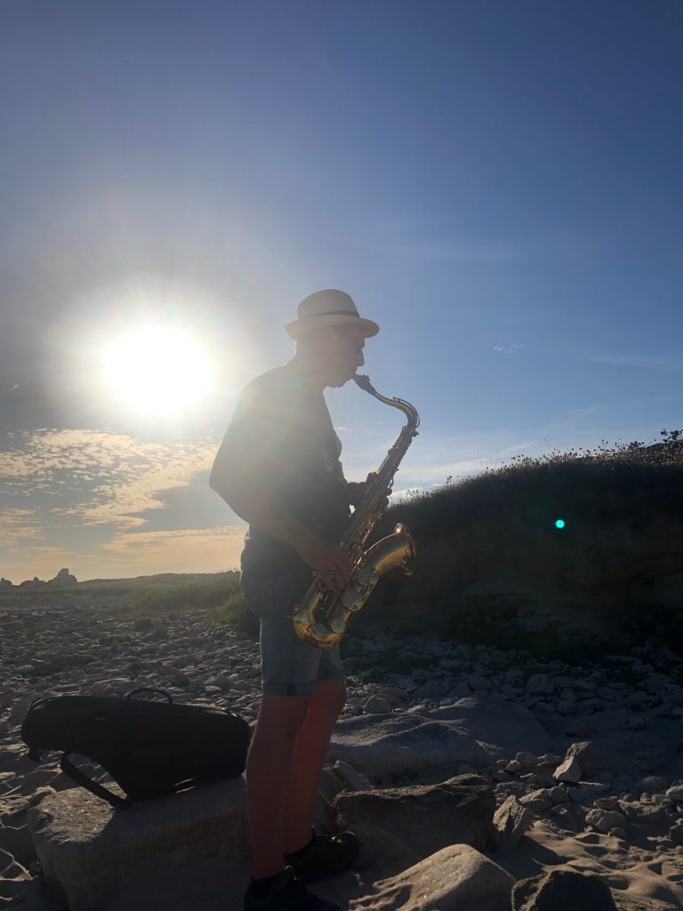 Saxophon am Strand im Gegenlicht